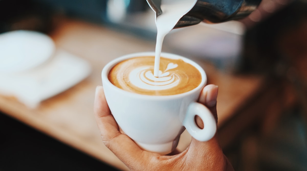 Iced latte with creamy foam in a glass