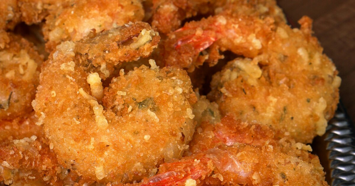 Crispy bang bang shrimp in a bowl with creamy sauce and garnish