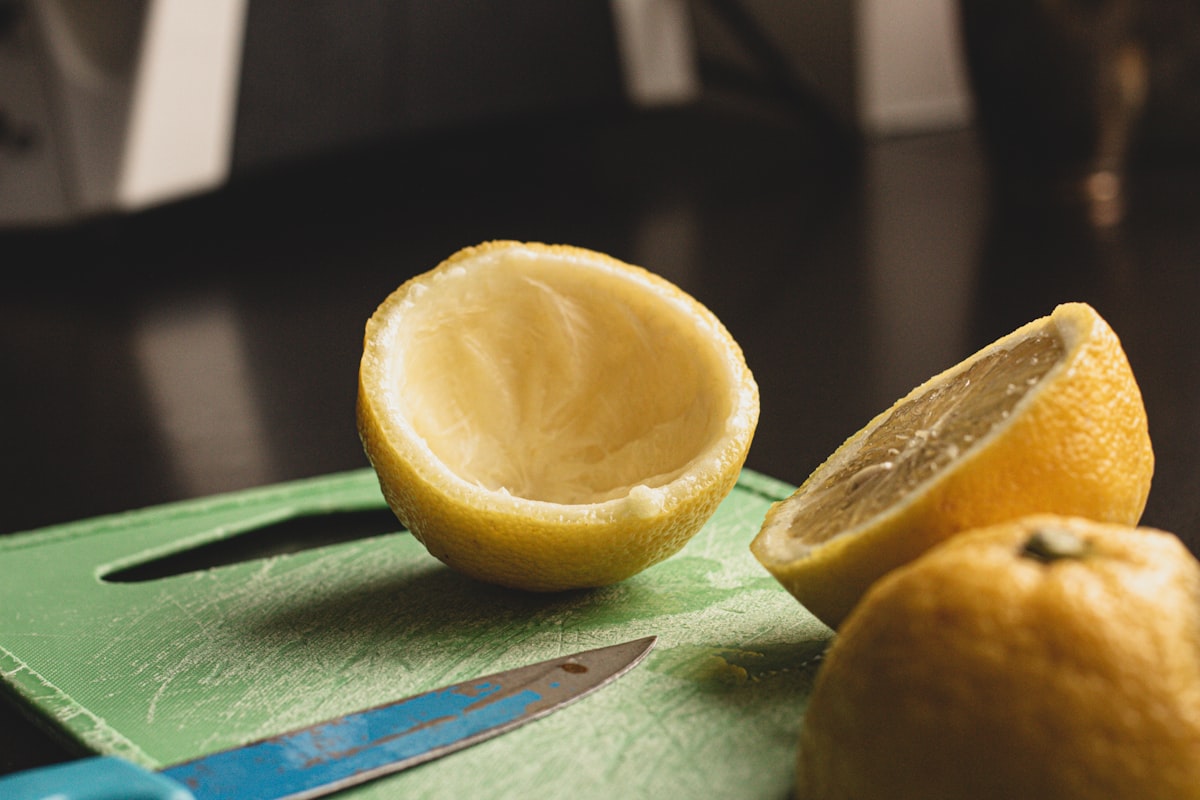 Freshly cut lemon on a cutting board with a knife