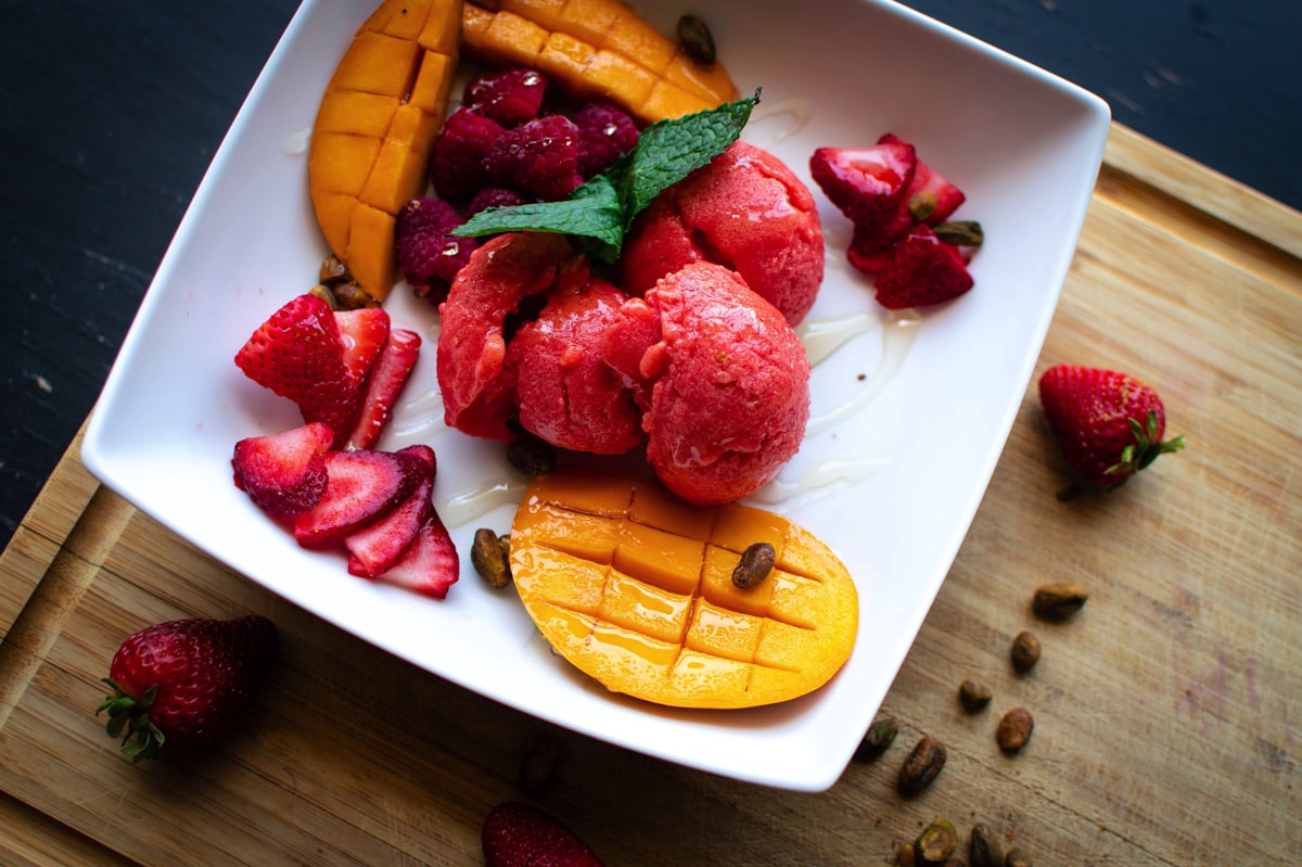 Scoops of vibrant purple frozen grape sorbet in a chilled bowl