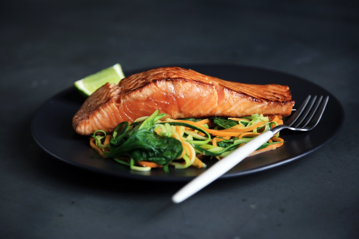 Hot honey glazed salmon bites on a plate with sesame seeds and green onions