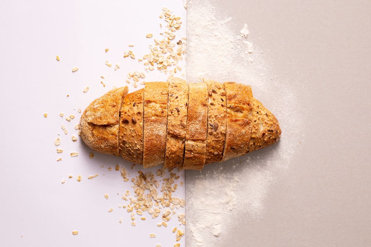 Golden fresh bread rolls with flaky sea salt on a wooden surface