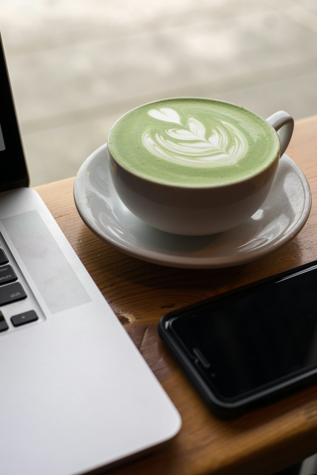 Matcha powder and green tea latte in a ceramic bowl