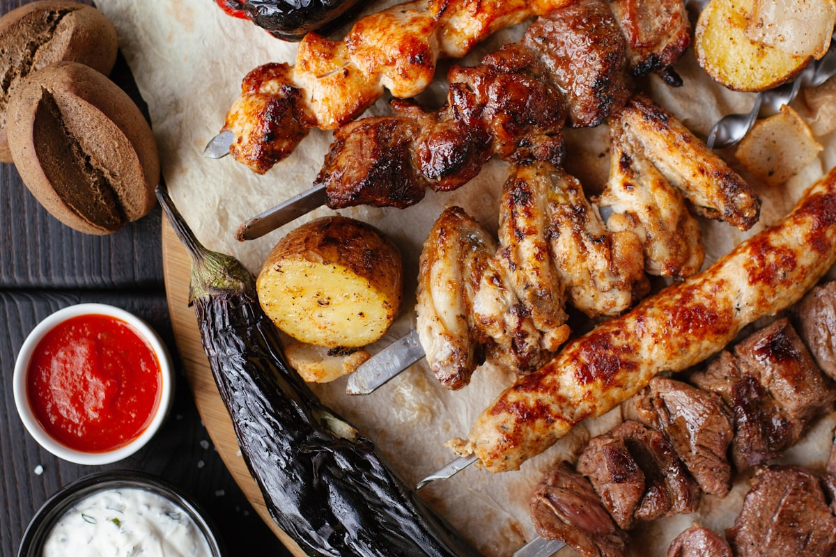 A spread of grilled meats, skewers, and sauces for a backyard BBQ
