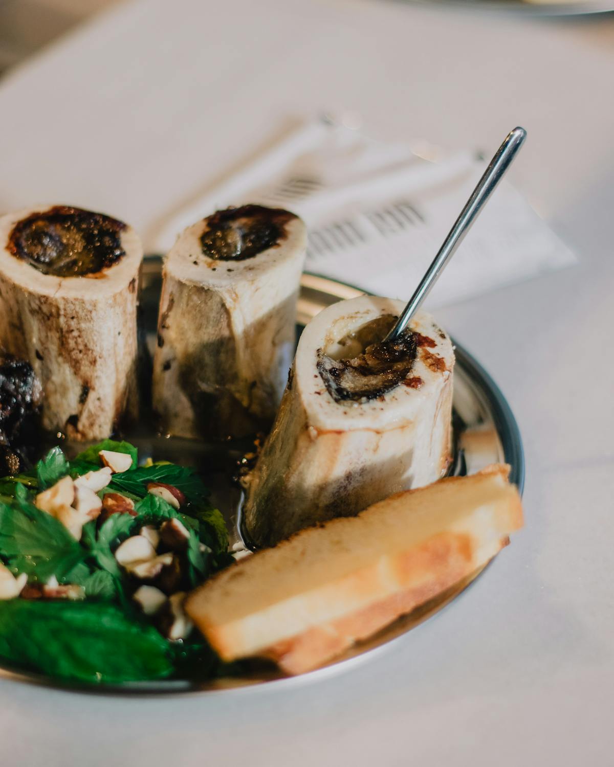 Roasted bone marrow served with salad on a plate
