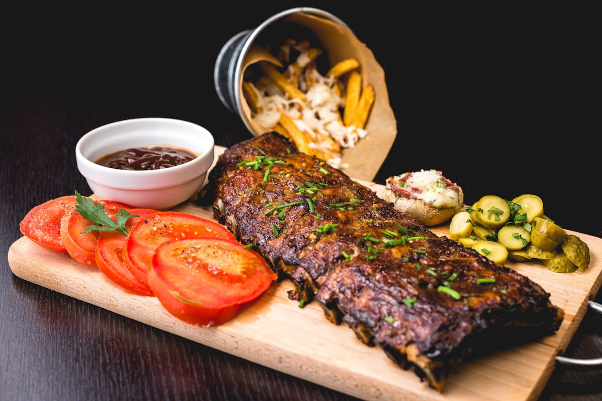Sliced grilled skirt steak with chimichurri sauce on a wooden board