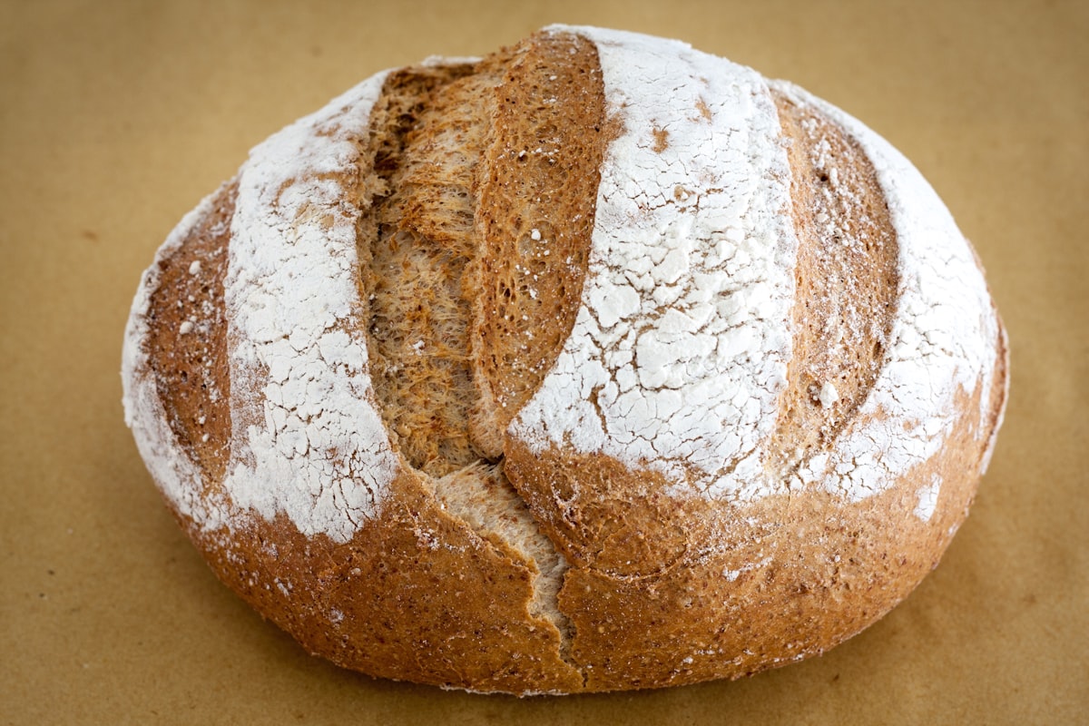 Rustic sourdough bread loaf dusted with flour on parchment paper