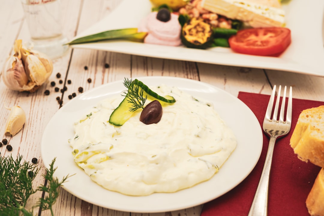 Creamy whipped feta dip with cucumber, dill, and olives on a plate